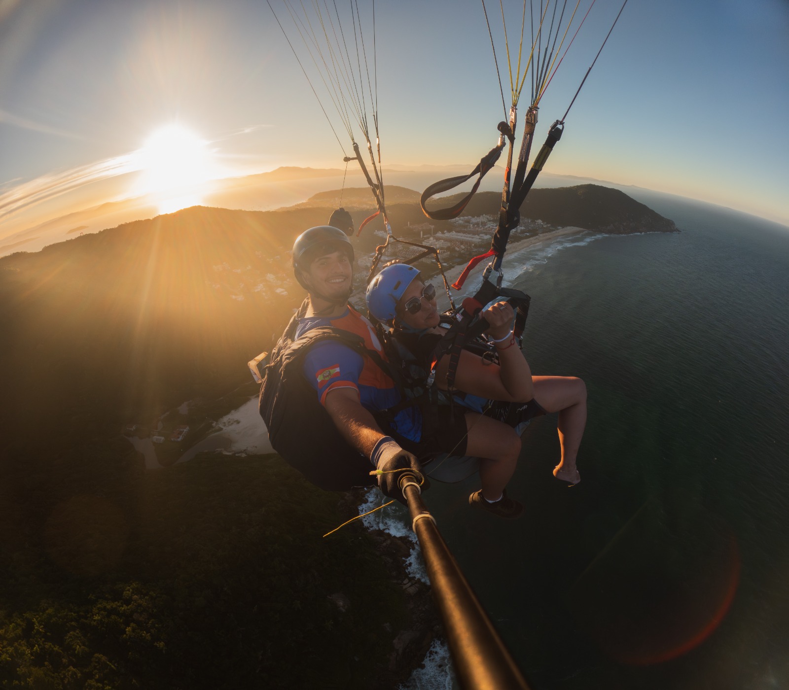 Decolagem de parapente na encosta verde da Praia Brava
