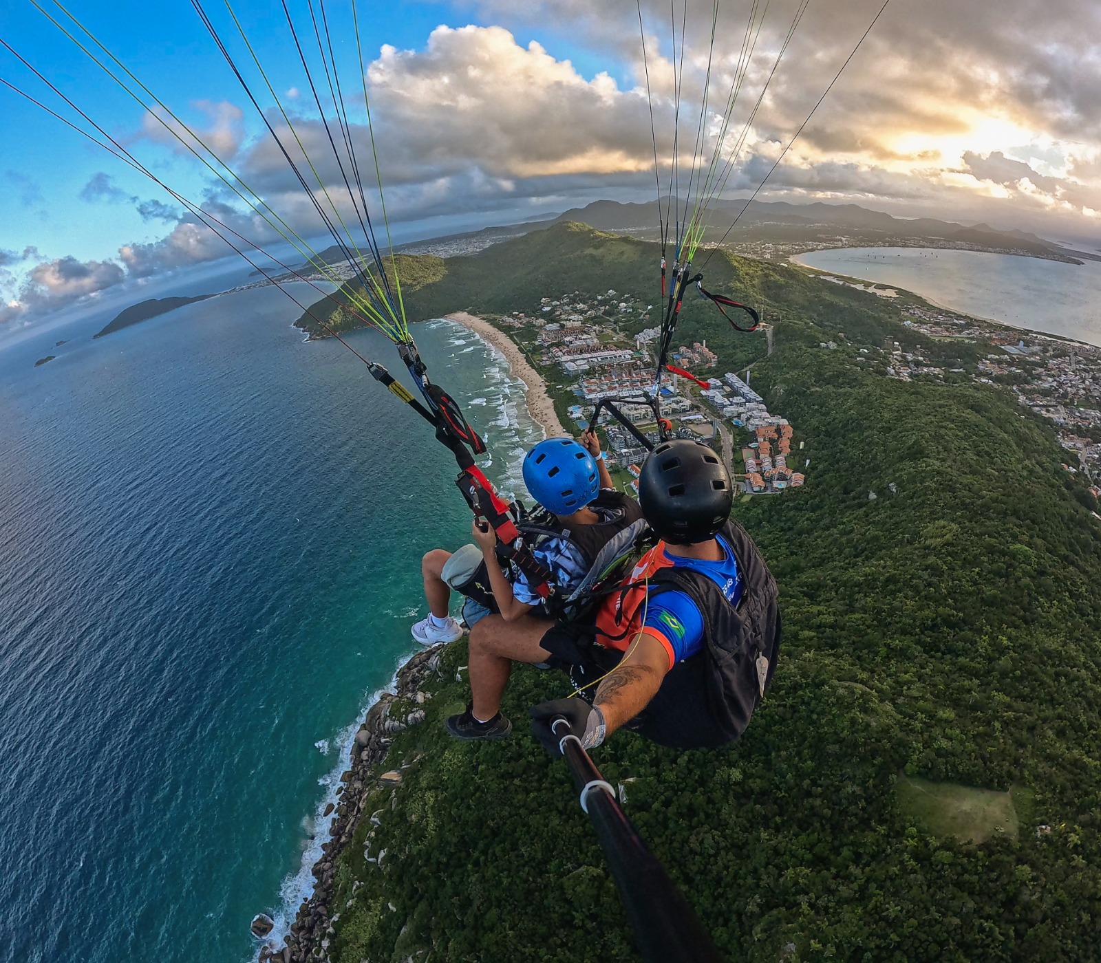 Vista de cima do parapente colorido com o passageiro sorrindo